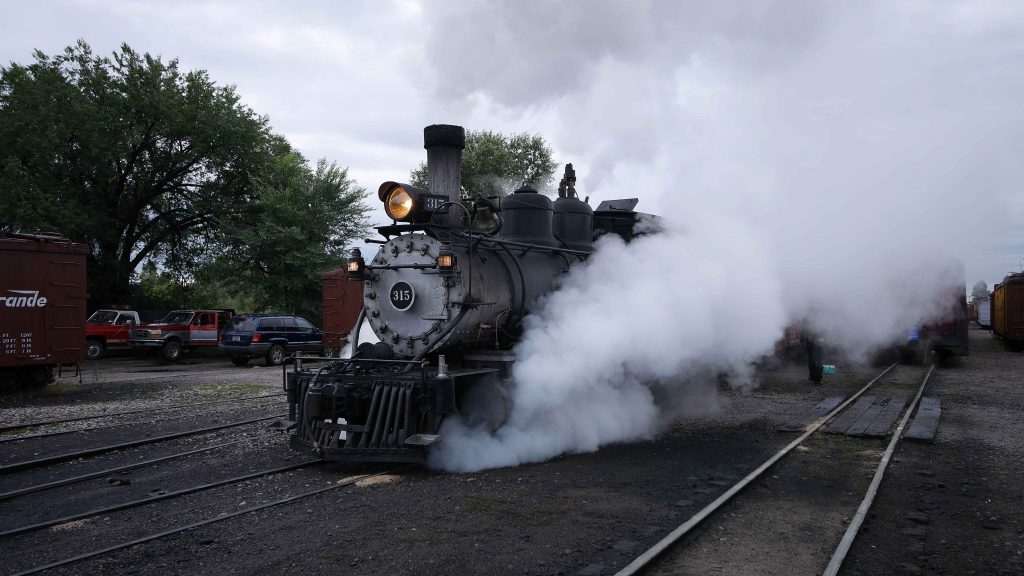 It's Thursday and it's raining as D&RGW 315 departs Chama for Cumbres in front of 12 freight cars. (Photo Mark Kasprowicz)